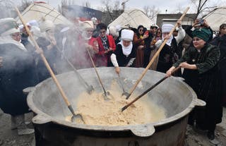 Iranians cook a traditional dish Sumulyk during celebrations for an ancient festival marking the first day of spring in Central Asia